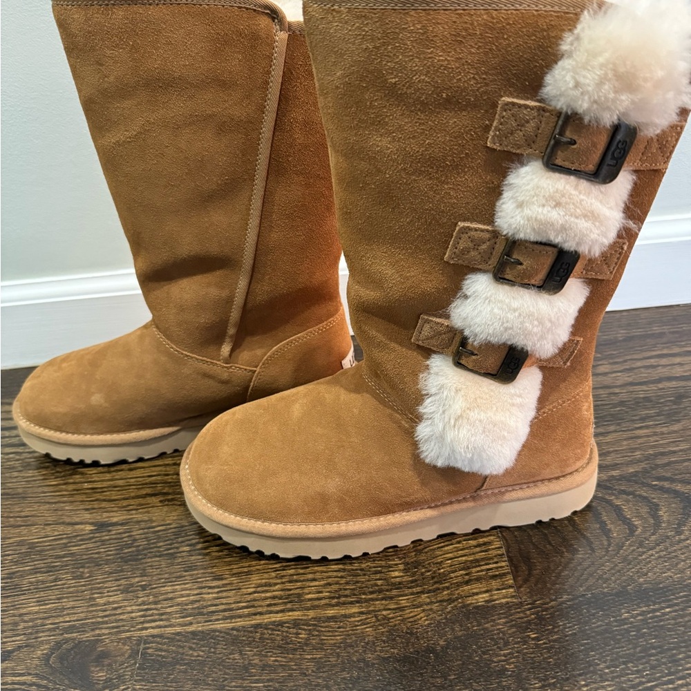 UGG Tan Winter Boots with cream fur and fux buckle detail. New in box.